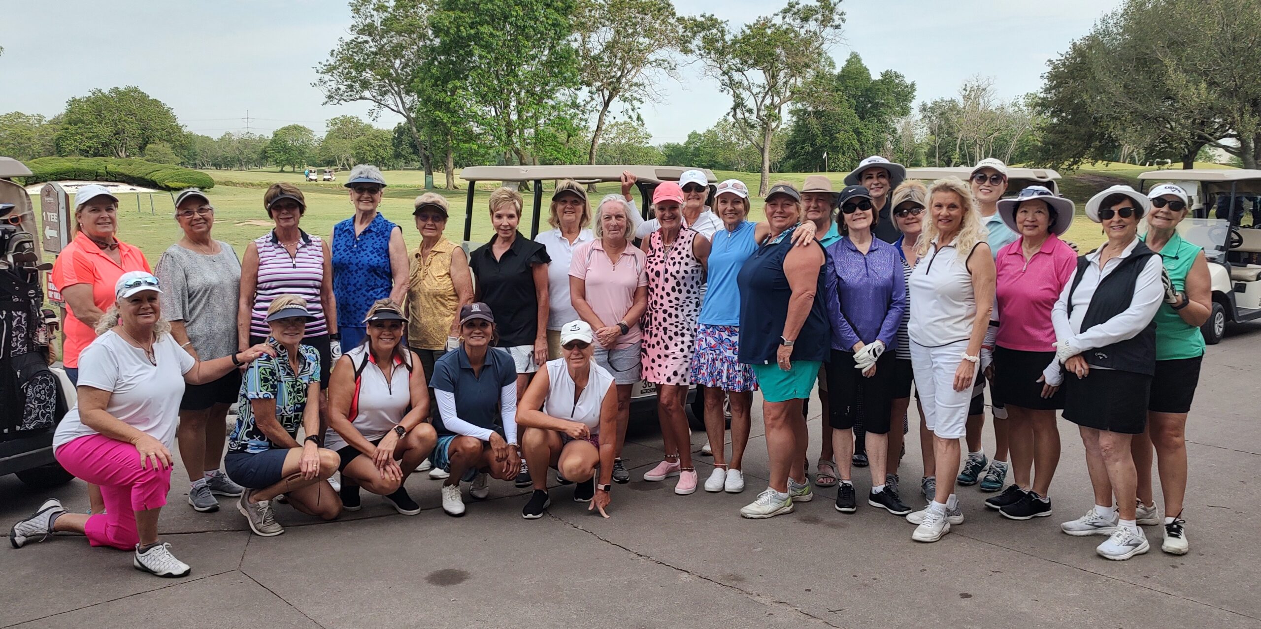 ladies group in front of golf carts for tournament